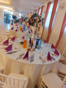 une grande table blanche avec des serviettes et des chaises violettes dans l'établissement Dor de Han, 