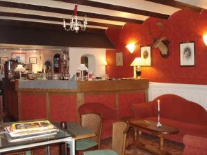 a restaurant with a bar and a table and chairs at Hotel La Fayette in Rochefort