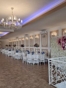 une salle de banquet avec des chaises et des tables blanches ainsi qu'un lustre dans l'établissement Dor de Han, 