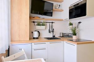 a kitchen with white cabinets and a counter with plants at Pokój 24E in Sobieszewo