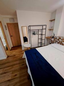 1 dormitorio con 1 cama blanca grande y suelo de madera en LOS PISOS DE CONCHA, en Benidorm