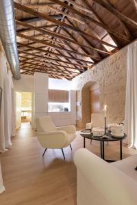 una sala de estar con muebles blancos y techo de madera. en La Posada De Sojo en Córdoba
