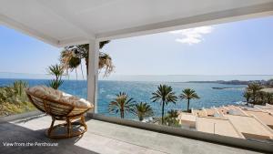 a chair on a balcony with a view of the ocean at Deva Beach Boutique Apartments in San Bartolomé