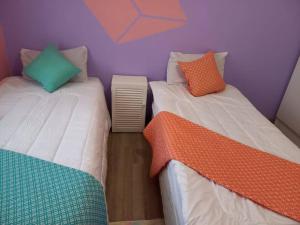 1 dormitorio con 2 camas y almohadas coloridas. en Comfy hidden home in Mthatha, en Mthatha