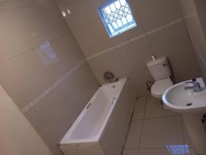 a bathroom with a toilet and a bath tub and a sink at Comfy hidden home in Mthatha in Mthatha