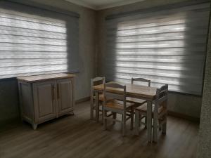 a dining room with a table and chairs and windows at Comfy hidden home in Mthatha in Mthatha