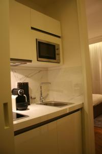 a kitchen with a sink and a microwave at Cirque Deluxe Studio Apartment in Paris