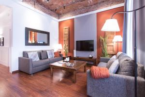 a living room with two couches and a coffee table at Serennia Apartamentos Ramblas - Plaça Catalunya in Barcelona