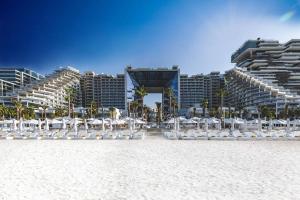 a group of chairs on the beach in front of a resort at Private Pool Apt. Five Palm Jumeirah up to 6guest in Dubai