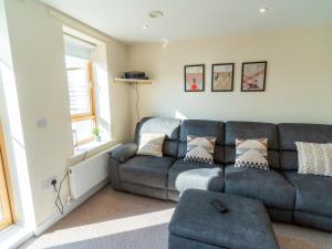 a living room with a gray couch and a window at Pass the Keys New 3bedroom house with free parking on premises in Nottingham