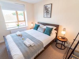 een slaapkamer met een groot bed en handdoeken bij Pass the Keys New 3bedroom house with free parking on premises in Nottingham