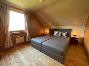 ein Schlafzimmer mit einem Bett in einem Zimmer mit einem Fenster in der Unterkunft JS Feriendomizile Haus Sonnenschein Bettwäsche Handtücher inkl in Hasselfelde