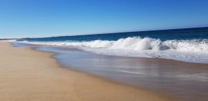 a beach with waves crashing on the shore at Blue Seas Holiday Villas in Scamander