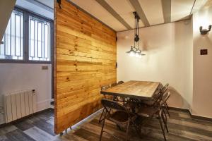 uma sala de jantar com uma parede de madeira em BBarcelona Dúplex Poble Sec em Barcelona
