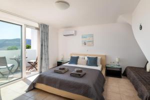 Un dormitorio con una cama grande y un balcón. en Villa Paradeiso with Private Pool, en Lindos