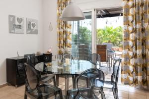 Un comedor con una mesa de cristal y sillas. en Villa Paradeiso with Private Pool, en Lindos 9 fotos más