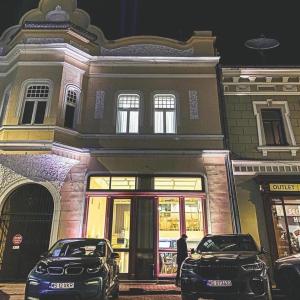 two cars parked in front of a building at night at Zakarias Apartments in Miercurea-Ciuc