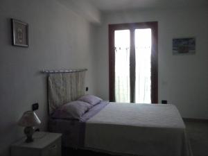 a bedroom with a bed and a window at Da Antonio in Càbras