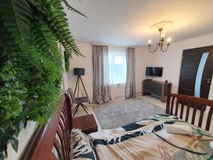 a bedroom with a bed and a plant at La Cuib in Câmpulung Moldovenesc