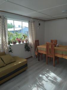 ein Wohnzimmer mit einem Sofa, einem Tisch und einem Fenster in der Unterkunft Antawara in Chile Chico