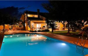 a swimming pool in front of a house at night at Agradable Villa junto al mar con piscina in Valencia