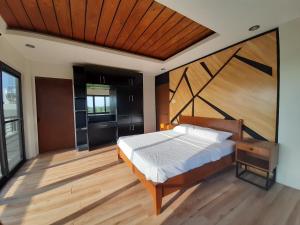 a bedroom with a large bed with a wooden headboard at Winch House in Pili