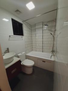Pili的住宿－Winch House，白色的浴室设有卫生间和水槽。