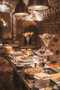 una mesa larga con platos de comida y copas de vino en Hotel Apia en Vilna