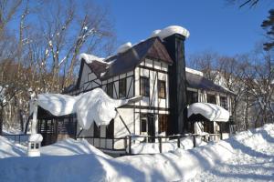 una casa cubierta de nieve con un montón de nieve en Hakuba House, en Hakuba