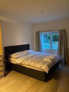 1 dormitorio con cama y ventana en Vöens, St-Blaise, Logement entier - 2 chambres, en Marin