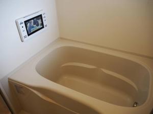 Harbour Inn & Suites 202 في نيغاتا: حوض استحمام في حمام مع صورة على الحائط