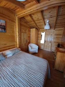 a bedroom with a bed in a wooden cabin at El Molino de Candelario in Candelario