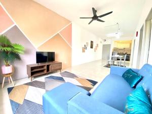 a living room with a blue couch and a tv at De'Colour Stay at Country Homes Rawang in Rawang