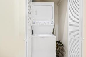 a white laundry room with a washer and dryer at Lincoln Park Gem in Chicago