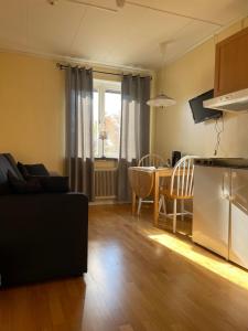 a living room with a couch and a table at Brålanda Hotell och Vandrarhem in Brålanda