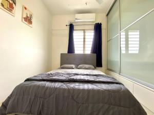ein Schlafzimmer mit einem Bett in einem Zimmer mit einem Fenster in der Unterkunft De'Colour Stay at Country Homes Rawang in Rawang