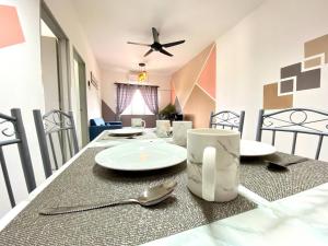 einen Esstisch mit einer weißen Platte und einem Löffel in der Unterkunft De'Colour Stay at Country Homes Rawang in Rawang
