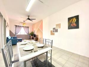 a dining room and living room with a table and chairs at De'Colour Stay at Country Homes Rawang in Rawang +4 photos