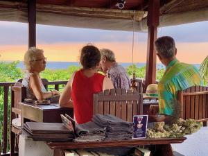 a group of people sitting at a table looking at the ocean at Fort Dew Guest House in Galle