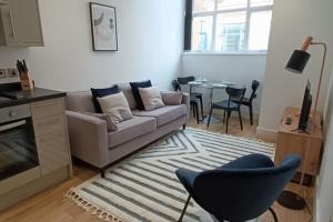 a living room with a couch and a table at Stunning mill apartment near to city centre and Etihad stadium! in Manchester