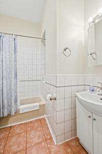 a white bathroom with a shower and a sink at Lincoln Park Gem in Chicago