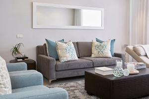 a living room with a couch and a chair at African Elite Waterfront in Cape Town