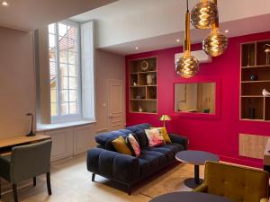 uma sala de estar com um sofá azul e uma parede vermelha em Suite avec Spa Quartier Cathédrale em Autun
