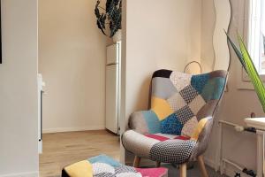 uma sala de estar com uma cadeira e um frigorífico em Lovely 7th floor studio full of color, enjoy! em Tampere