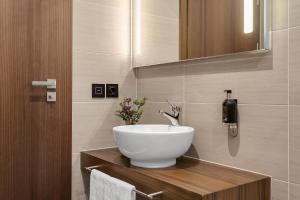 a bathroom with a white bowl sink on a wooden counter at Alva Hotel in Reykjav&iacute;k