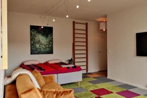 1 dormitorio con 1 cama con escalera y TV en Lovely 7th floor studio full of color, enjoy!, en Tampere