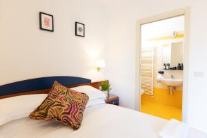 a bedroom with a white bed with a pillow on it at Residence Mimosa in Rimini