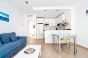 a living room with a blue couch and a table at Apartamentos Delamar in Carboneras