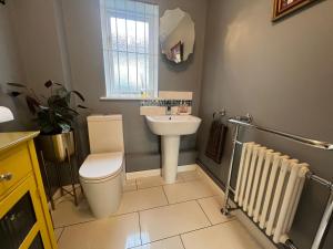 een badkamer met een toilet en een wastafel bij La Mignonne Aketoise in Peterborough