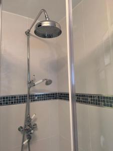 a shower with a shower head in a bathroom at La Mignonne Aketoise in Peterborough